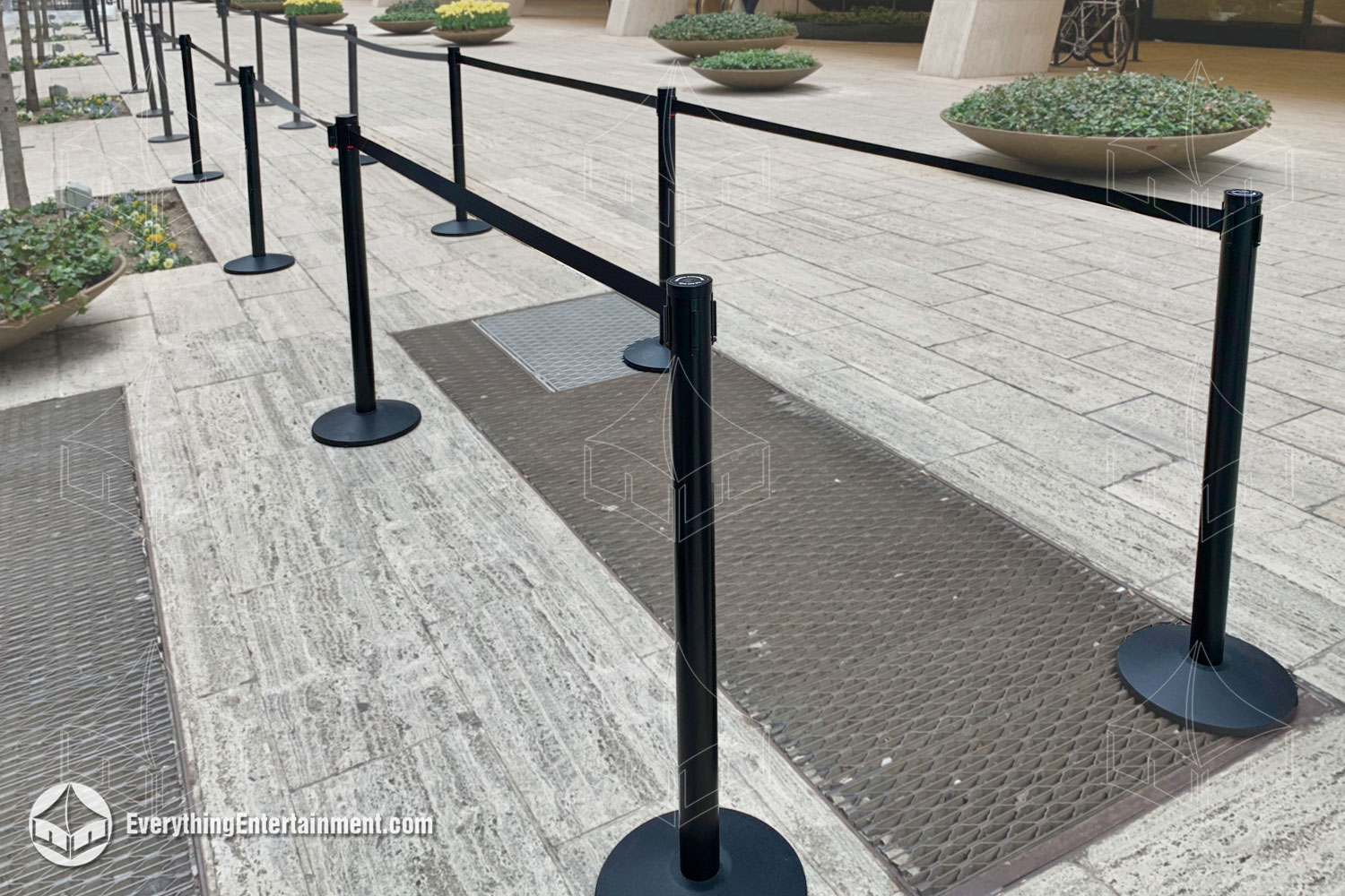 black retractable belt stanchions set up in a long run in a NYC Sidewalk