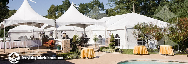 Several frame tents with walls setup in a backyard with a pool in the foreground.