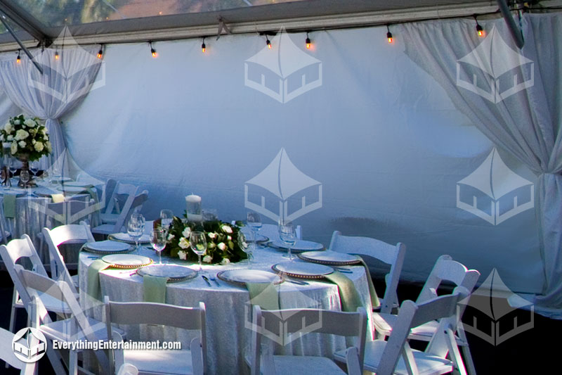 White tent sidewall with leg drapes plus table and chairs